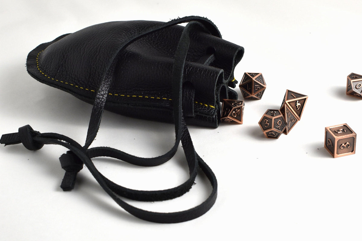 Open handcrafted black leather drawstring pouch showing spacious interior for coins, dice, jewelry, cash, keys, and everyday carry items.