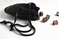 Open handcrafted black leather drawstring pouch showing spacious interior for coins, dice, jewelry, cash, keys, and everyday carry items.