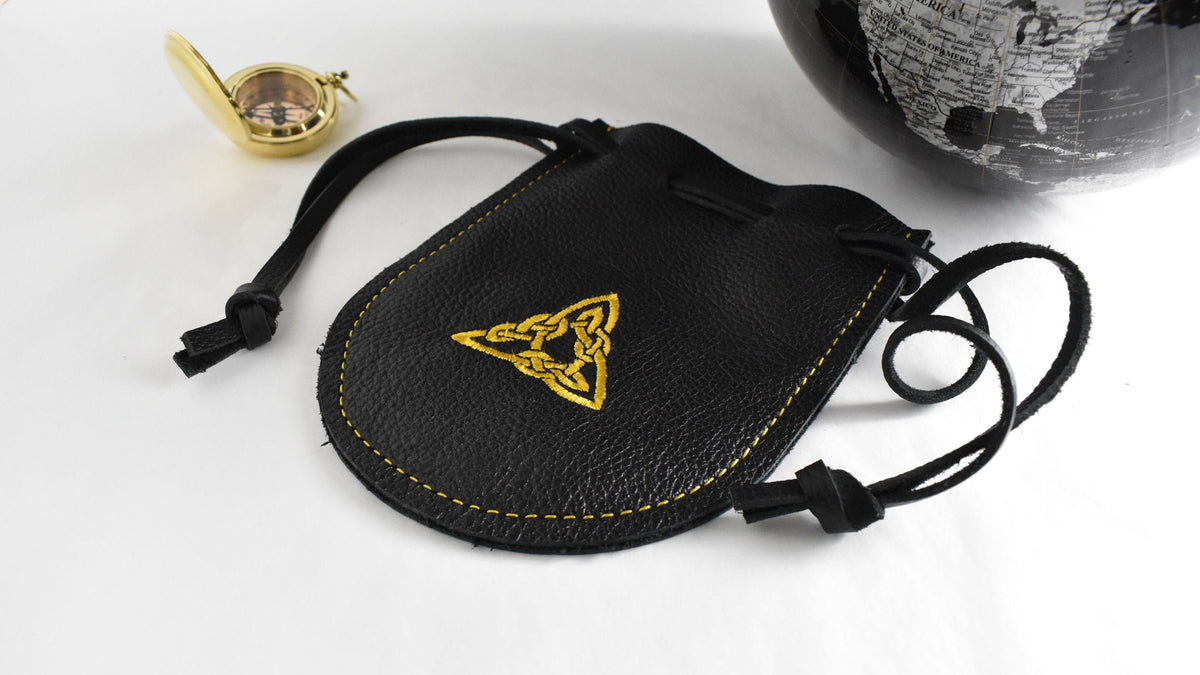 Handcrafted black leather drawstring pouch featuring a gold embroidered triangle design for everyday carry, travel, dice, and collectibles.  Made in the USA